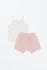 Flat lay of Avauma apricot daisy baby tank set – white floral sleeveless top with pink trim and apricot-pink shorts